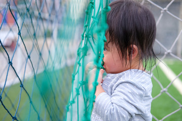 Cute asian baby girl playing on football field. Portrait of Asian beautiful baby girl of 1 year and 3 months old.