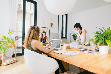 Three women working together to launch a creative startup