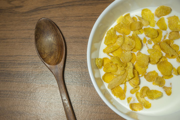 Cornflakes Cereal  with warm milk  in white bowl morning snacks.