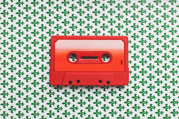 Red cassette tape on pattern background 