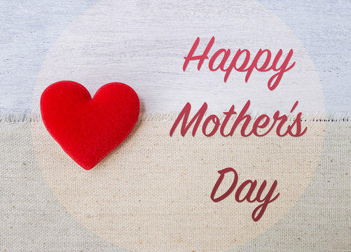Happy Mother's day card concept, red heart with message on canvas fabric over white wood background