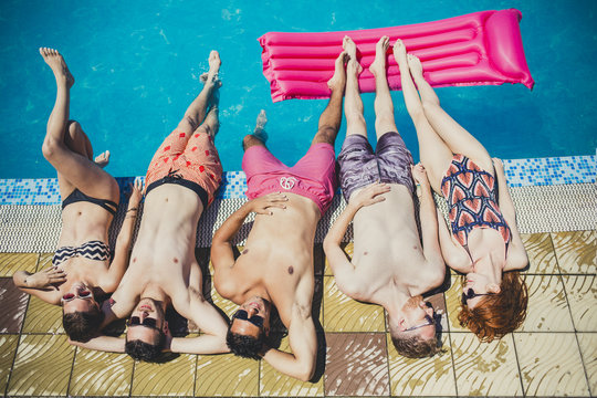Group of Young People Lying by the Swimming Pool