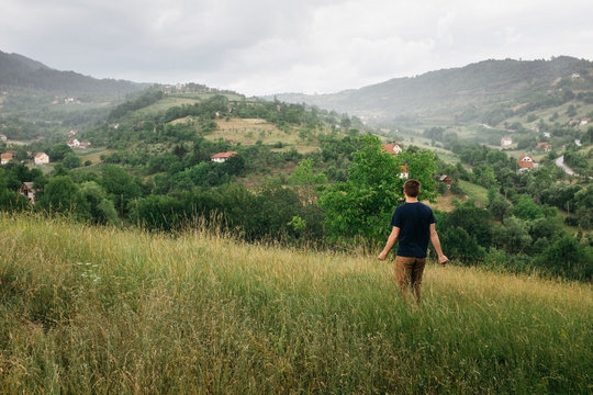 young male outdoors on valley hillside in rain