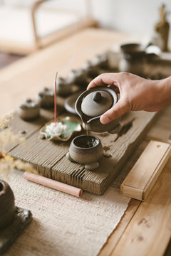 Serving Chinese tea into ceramic tea cups