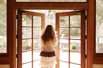 Redhead woman opening house door