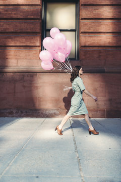 The girl with pink balloons