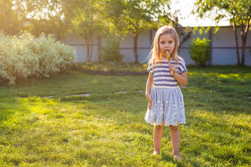 Funny child with candy lollipop, happy little girl eating big sugar candy.