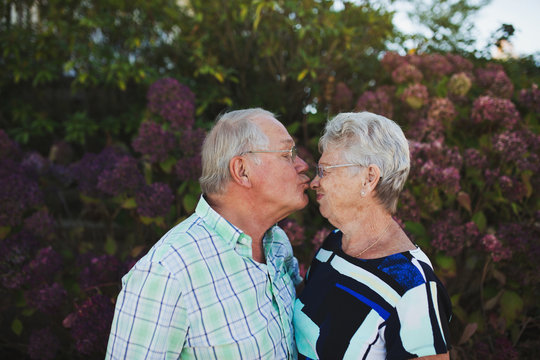 Happy senior couple outside enjoying kiss together