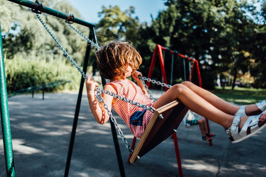 Girl swinging on the swing in the park