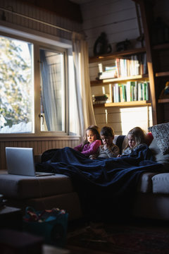 Three Kids Watching Laptop Inside During Winter Day