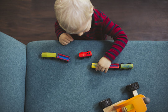 Blond Boy Playing With Toy Cars