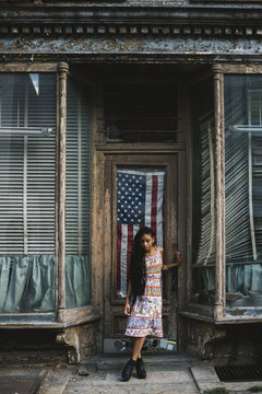 Young woman against old house and USA flag