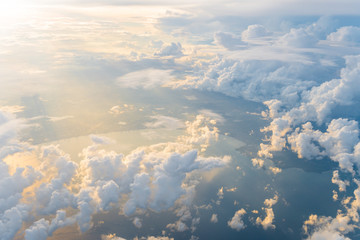 White clouds and blue sky at sunrise, view from above air plane window. - Powered by Adobe