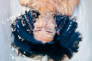 Woman holding breath underwater in the bathtub