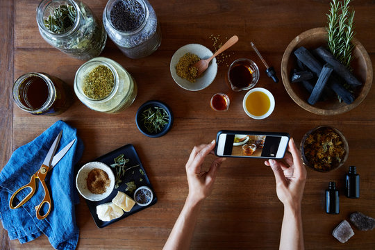 Small business owner taking a photo of her products she made