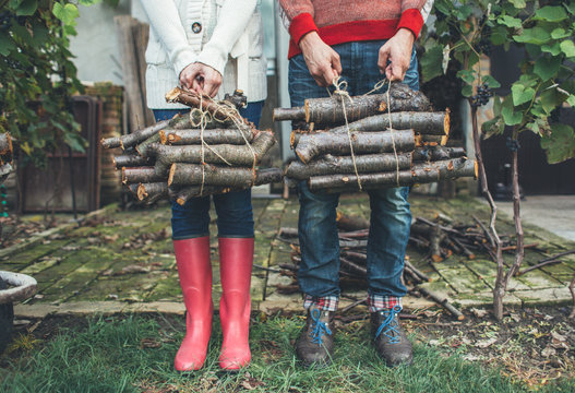 Man and woman holding chopped wood sticks