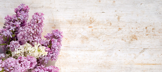 bouquet of white and violet lilac flowers on a wooden table with copy space
