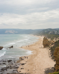 Fototapeta na wymiar Long sandy beach with cliffs and gentle waves