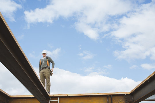 Construction worker standing on steel beam at construction site