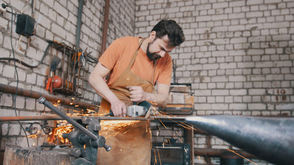 Blacksmith forging an knife with circular saw