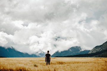 A man quietly  awaits an impending storm on the New Zealand valley horizon