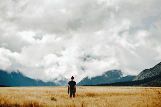 A man quietly  awaits an impending storm on the New Zealand valley horizon