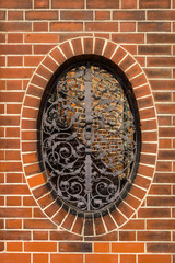 Wrought iron grille with floral patterns on the oval window.