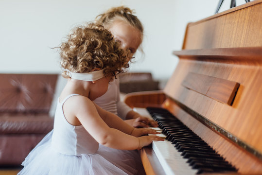 Sisters playing a piano
