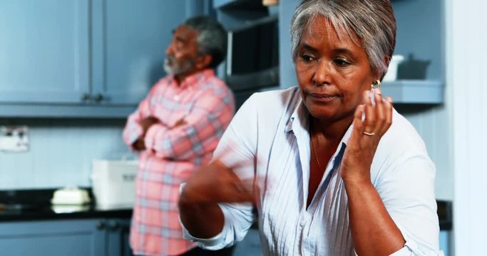 Senior couple ignoring with each other in kitchen