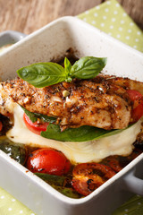 Balsamic chicken fillet baked with caprese close-up in a baking dish. vertical