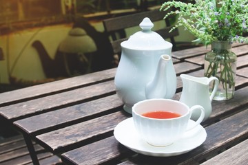 Tea time on wooden table in cottage garden