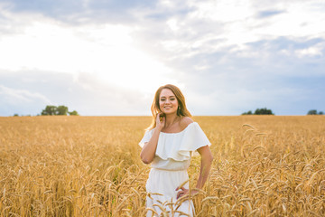 happiness, nature, summer, autumn, vacation and people concept - young woman in the field.