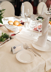 Blank card for guests near white empty plate on dinner table for wedding banquet, free space for text