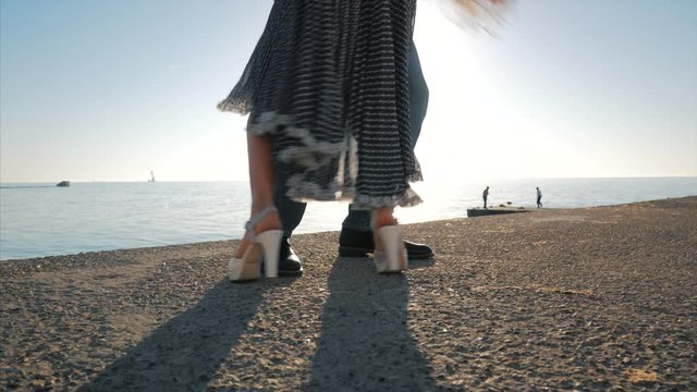 Energetic attractive young couple dancing latin Bachata near sea or ocean. Sunlight background. Summer time, romantic footage