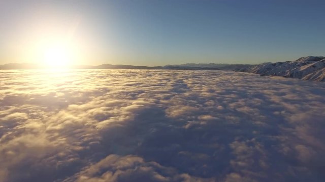 Flying over the clouds at sunrise