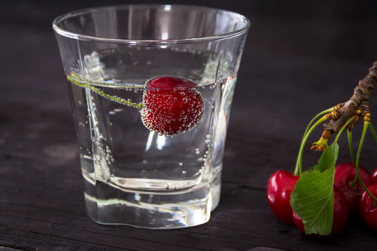 Cherry with bubbles in a glass of mineral water