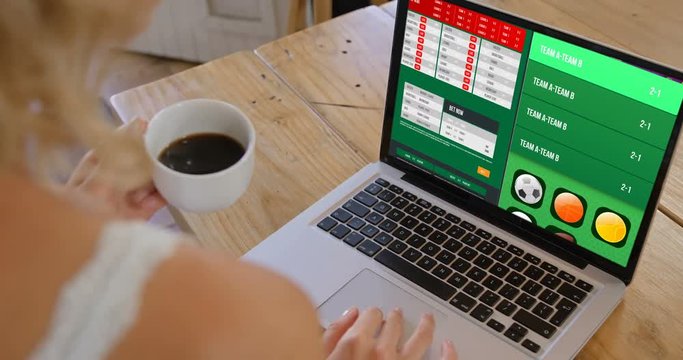 Woman watching football score on laptop