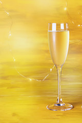 A glass of champagne on blurred golden background