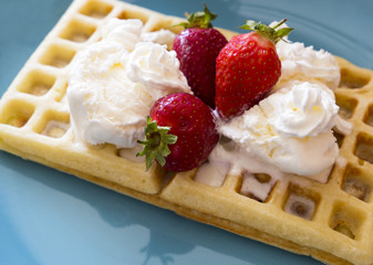 Homemade belgian waffles with whipped cream and strawberry