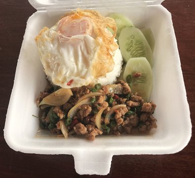 Spicy fried pork with basil leaves and fried egg in foam