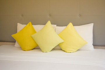Fototapeta na wymiar yellow pillows on white bed