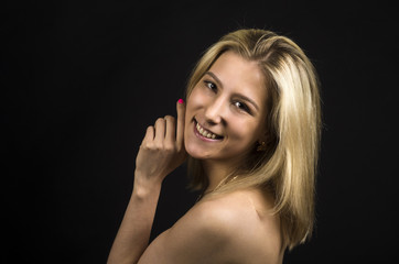Portrait of a smiling girl on a dark background.