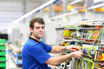 Portrait- Elektroniker montiert Maschine in einer Fabrik // Portrait of electrician assembling machine in a factory