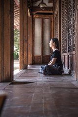 The girl sat beside the old House