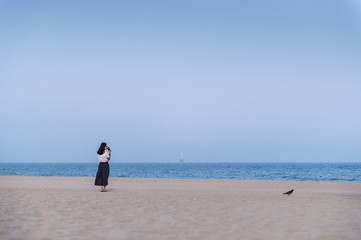 Fototapeta na wymiar The woman standing on the beach