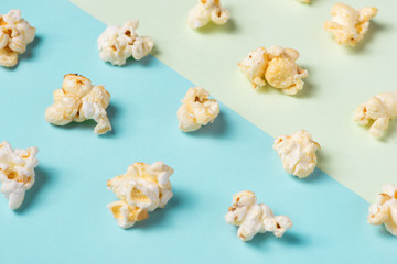 The popcorn in paper cup on green and blue background.