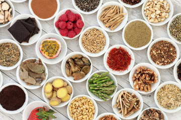 Aphrodisiac food sampler of foods to promote sexual health in china bowls on distressed wooden background.