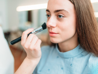Female make up artist applying make-up with brush