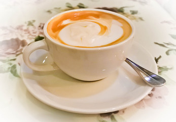 A white cup of coffee with fine milk foam, boost up in the morning.
