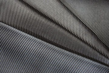 Black carbon fiber or Kevlar texture for background.